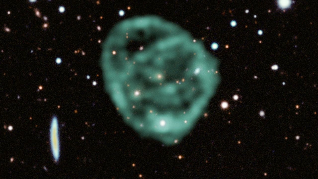 Data from the MeerKAT telescope (green) showing the odd radio circles is overlaid on optical and near-infrared data from the Dark Energy Survey.