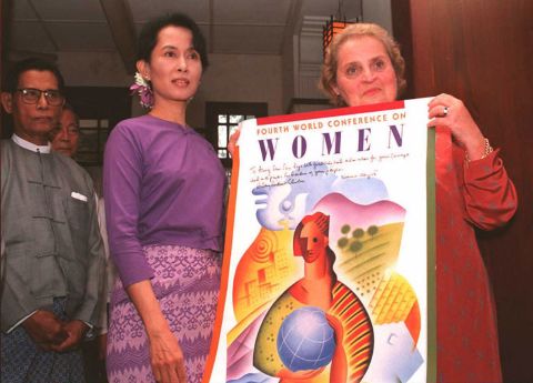 Albright presents a poster from the World Conference on Women as she meets with Myanmar political leader Aung San Suu Kyi in 1995.