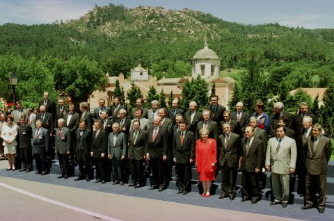Albright's red outfit stands out in a sea of suits as she poses with other foreign ministers during a NATO meeting in Lisbon, Portugal, in 1997.