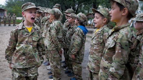 In this photo taken outside Kyiv on July 14, 2017, a student at a paramilitary camp for children calls the rank to attention. 