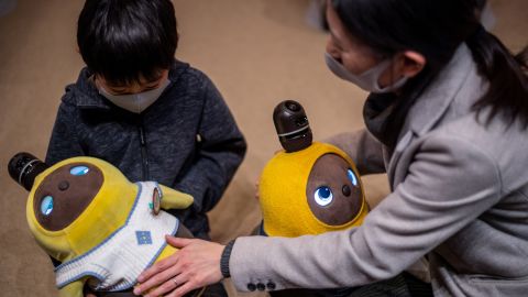 20 دسمبر 2020 کو جاپان کے کاواساکی کے ایک کیفے میں کھانے والے Lovot روبوٹس کے ساتھ بات چیت کر رہے ہیں۔