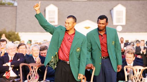 Tiger Woods waves as Vijay Singh looks on during the presentation ceremony of the 2001 Masters tournament.