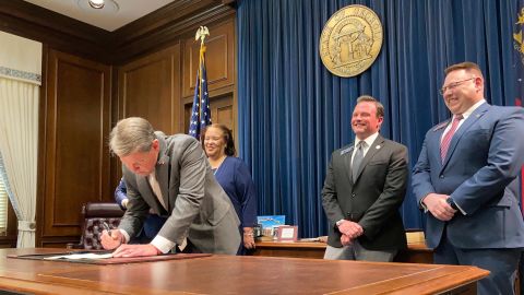 Georgia Gov. Brian Kemp signs a bill to give state income refunds of more than $1.1 billion on Wednesday, March 23, 2022, at the Georgia capitol in Atlanta. The measure gives refunds of $250 to $500 to people who filed tax returns for 2020 and 2021. 