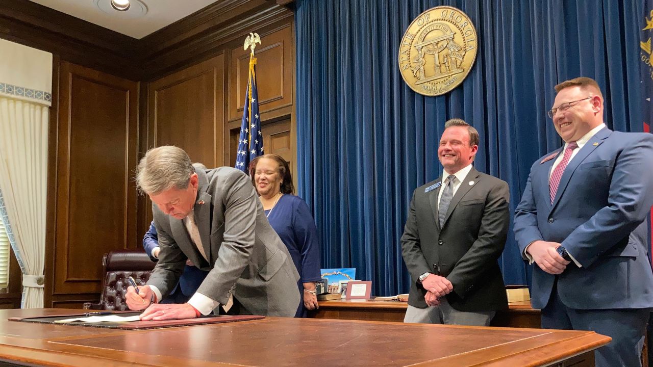 Georgia Gov. Brian Kemp signs a bill at the state Capitol in Atlanta on March 23, 2022, that will give income tax refunds of more than $1.1 billion to some Georgians.