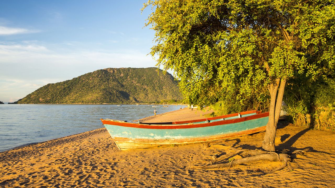 A boat is left on the beach at Cape Maclear on the shores of Lake Malawi in the nation of Malawi in southern Africa.