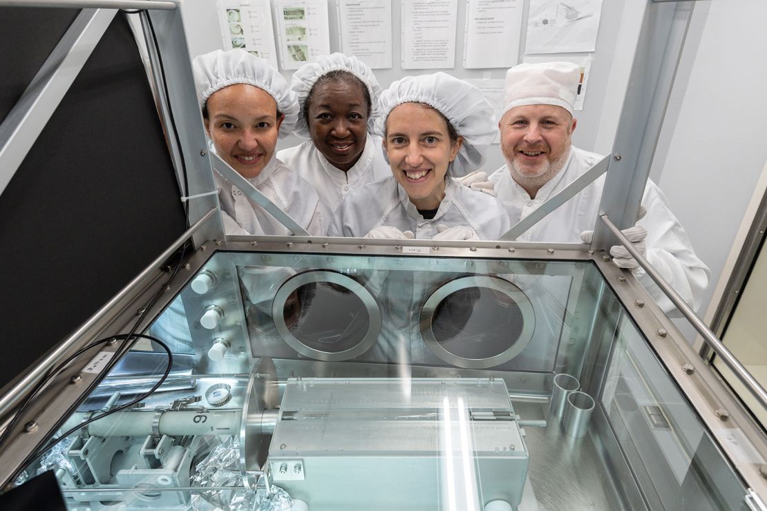 The processing team, including (from left) Charis Krysher, Andrea Mosie, Juliane Gross and Ryan Zeigler at NASA's Johnson Space Center, poses in front of the newly opened sample.
