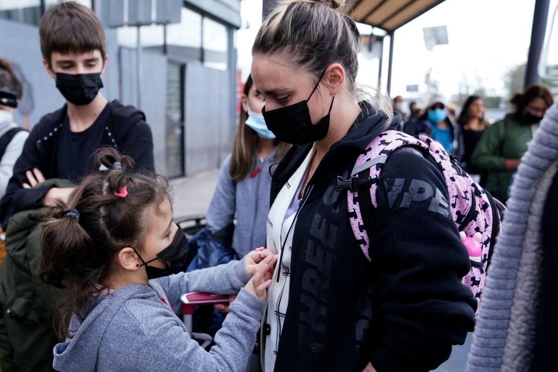A woman from Ukraine stands with her children before crossing into the United States. U.S. authorities allowed the woman and her three children to seek asylum on March 10, a reversal from a day earlier when she was denied entry.