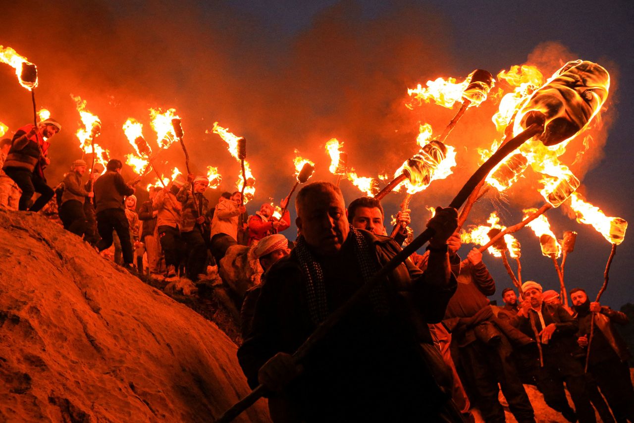 Men carry torches to celebrate Nowruz, the Persian New Year, in Akra, Iraq, on Sunday, March 20.