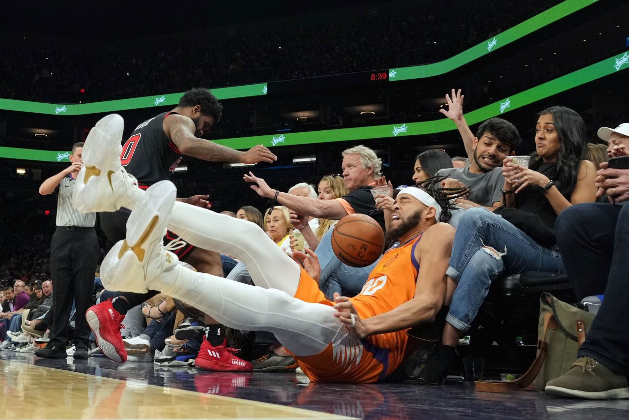 Phoenix center JaVale McGee falls into spectators while trying to save a ball from going out of bounds during an NBA game against Chicago on Friday, March 18.