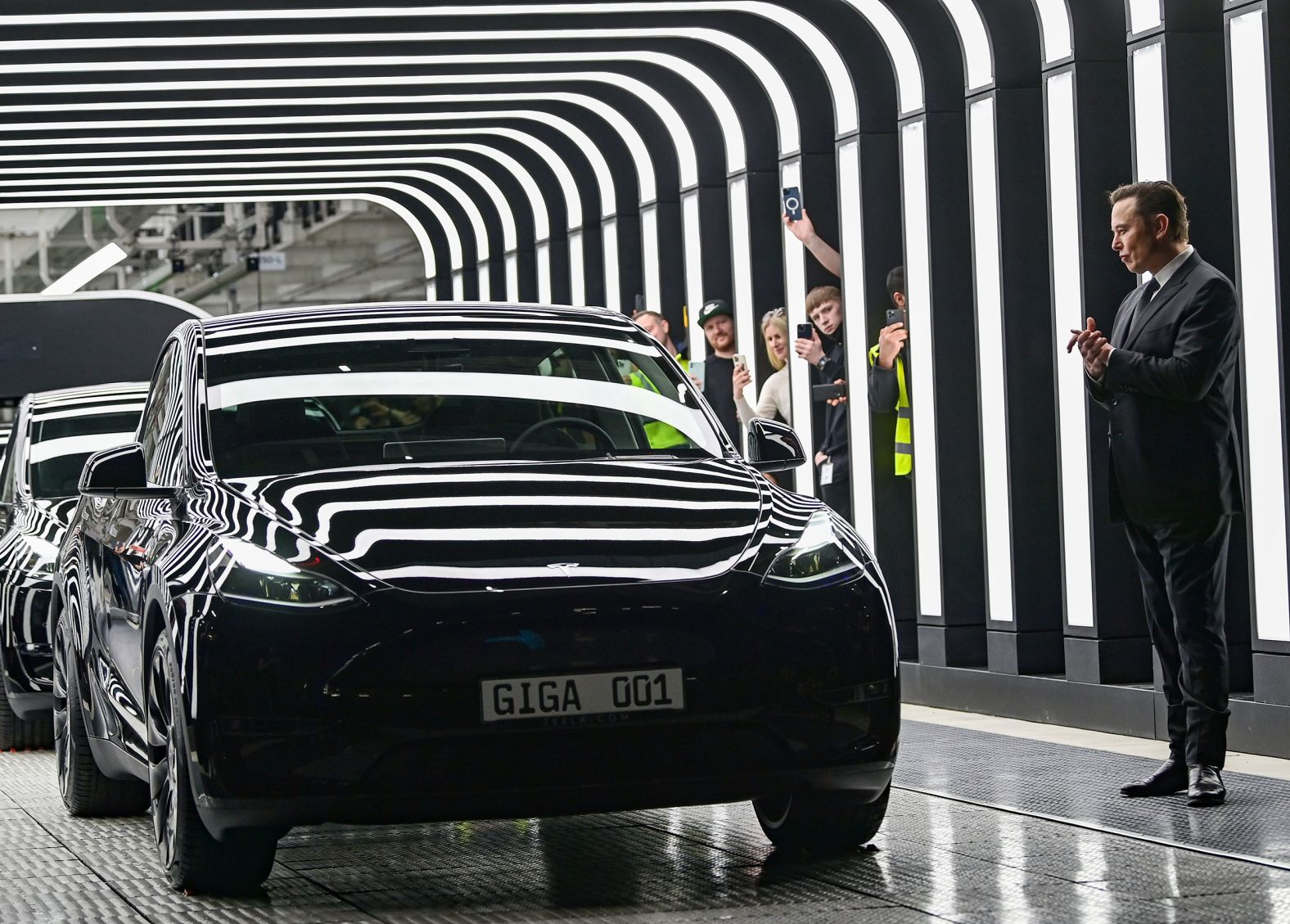 Tesla CEO Elon Musk, Tesla CEO, right, claps his hands at the <a href="index.php?page=&url=https%3A%2F%2Fwww.cnn.com%2F2022%2F03%2F22%2Fcars%2Ftesla-berlin-factory%2Findex.html" target="_blank">opening of a new factory</a> in Grünheide, Germany, on Tuesday, March 22. Tesla will reportedly produce as many as 500,000 vehicles a year at the plant.