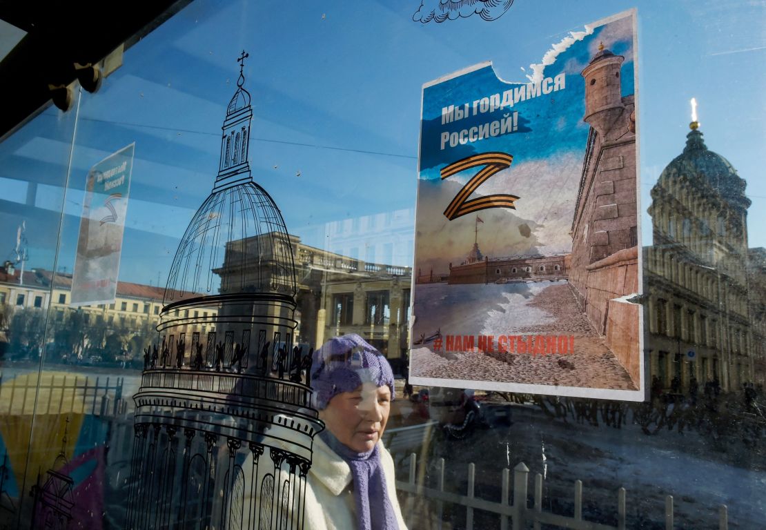 A woman in St. Petersburg walks past posters bearing the letter "Z" -- a letter that has become a symbol of support for Russian military action in Ukraine.