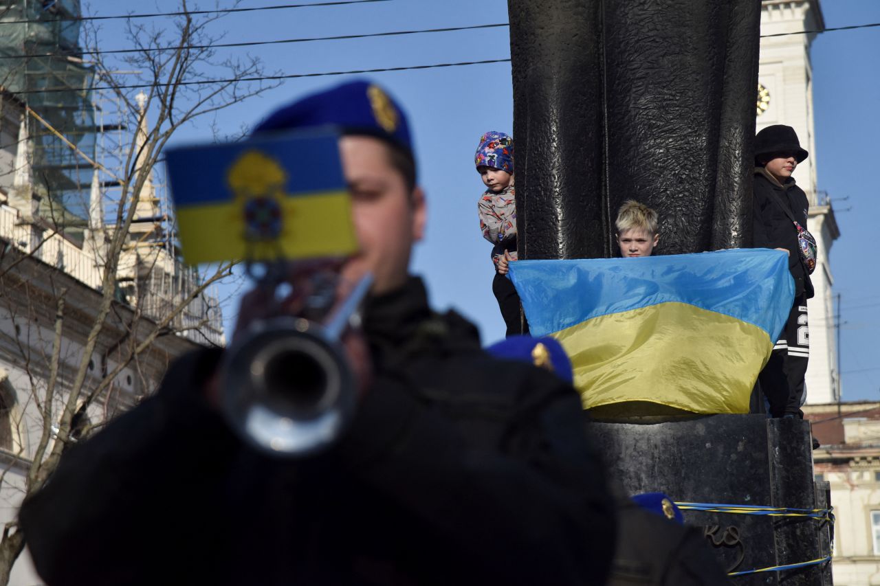 A child holds a Ukrainian flag in front of the Taras Shevchenko monument as members of the Ukrainian National Guard band perform in Lviv on March 24.