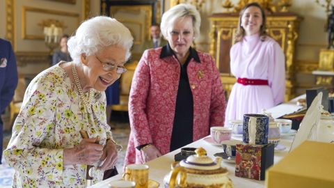 Queen Elizabeth II examines hand-decorated china at Windsor Castle.