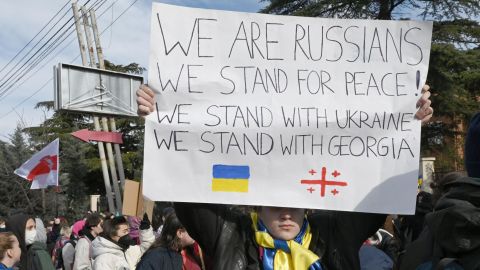An anti-war protester holds a placard during a rally in front of the former Russian embassy in Tbilisi on March 12.