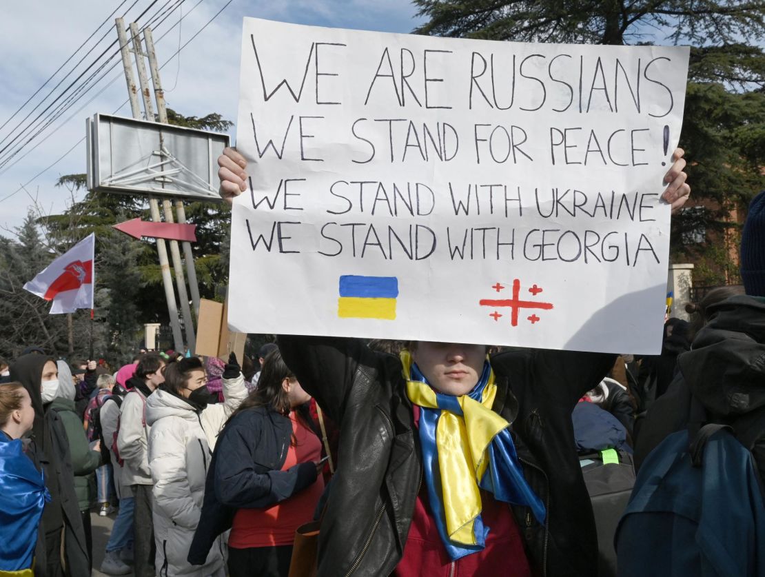 An anti-war protester holds a placard during a rally in front of the former Russian embassy in Tbilisi on March 12.