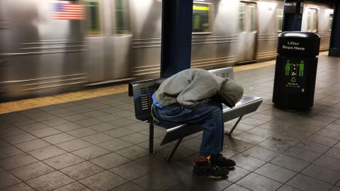 A homeless man sleeps in an empty station as workers close down the New York City subway system, the largest public transportation system in the nation.