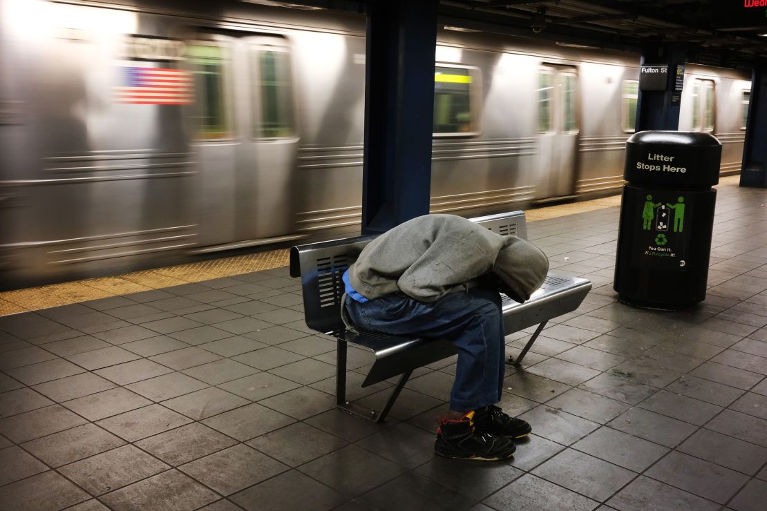 A homeless man sleeps in an empty station as workers close down the New York City subway system, the largest public transportation system in the nation.