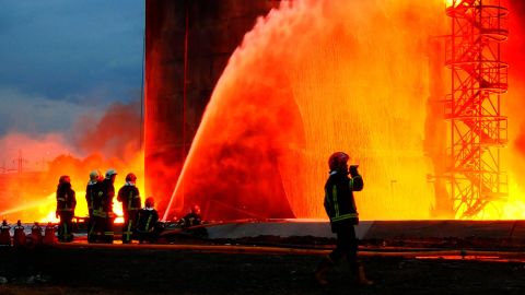 Firefighters try to extinguish a fire after Russian guided missiles hit a fuel storage facility in Lviv, Ukraine, on March 27.