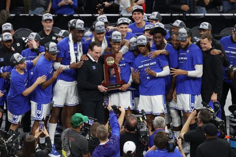 Krzyzewski and his players pose for photos after winning the West regional at the NCAA Tournament. The Blue Devils defeated Arkansas to book their spot in the Final Four.