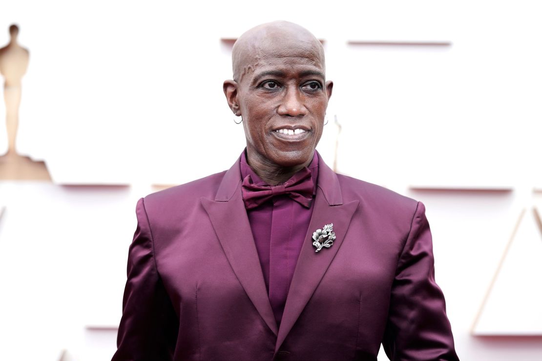 "Coming 2 America" actor Wesley Snipes in a custom Givenchy maroon look paired with silver hoop earrings.