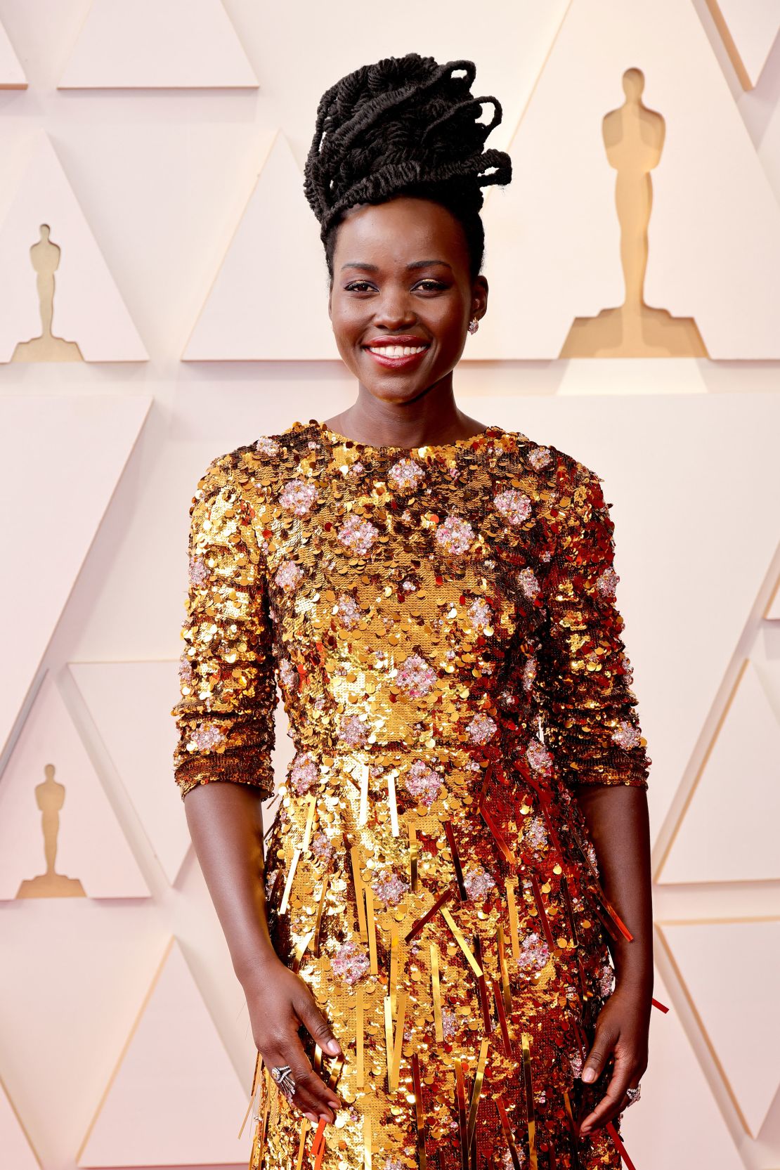 Actress Lupita Nyong'o in a gold-sequined Prada look with rose accents. 