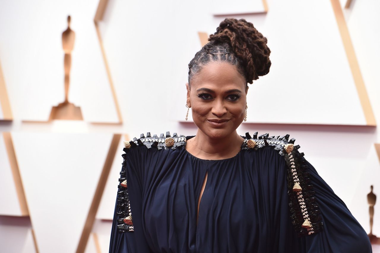 Filmmaker Ava DuVernay in a dark blue Louis Vuitton ensemble featuring elaborate shoulder pieces and detailing.