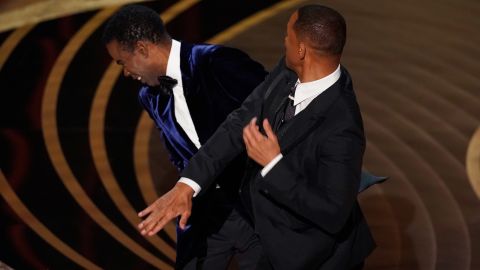 Will Smith, right, hits presenter Chris Rock on stage at the Oscars on Sunday.