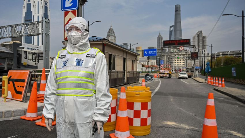 A transit officer, wearing a protective gear, controls access to a tunnel in the direction of Pudong district in lockdown as a measure against the Covid-19 coronavirus, in Shanghai on March 28, 2022. - Millions of people in China's financial hub were confined to their homes on March 28 as the eastern half of Shanghai went into lockdown to curb the nation's biggest Covid outbreak.