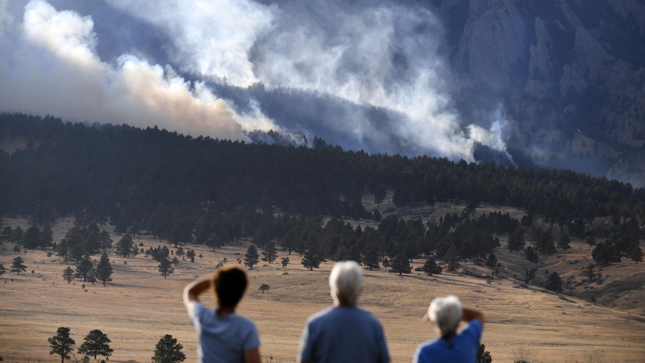 From left to right, Laura Tyson, Tod Smith and Rebecca Caldwell, residents of Eldorado Springs, watch as the NCAR Fire burns Saturday in Boulder, Colorado. 