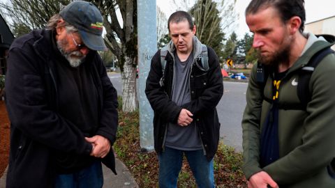 Carl Rhymes, Enoch Gerber and Mike Wade pray for the victims of a car crash that left four people dead Sunday at a homeless camp in Salem.