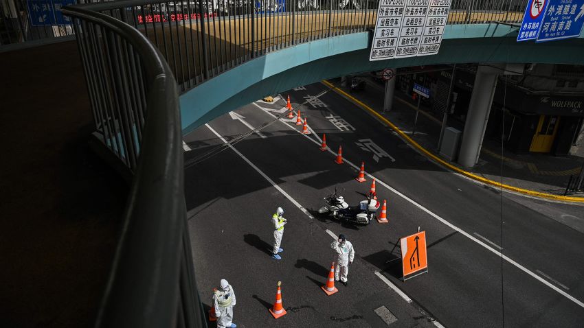 Transit officers, wearing protective gear, control access to a tunnel in the direction of Pudong district in lockdown as a measure against the Covid-19 coronavirus, in Shanghai on March 28, 2022. Millions of people in China's financial hub were confined to their homes on March 28 as the eastern half of Shanghai went into lockdown to curb the nation's biggest Covid outbreak.