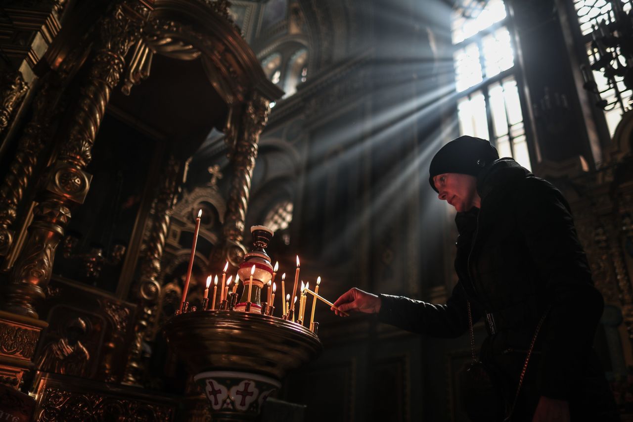 A woman lights a candle during the Sunday service at a monastery in Odesa on March 27.  Zelensky says Russia waging war so Putin can stay in power &#8216;until the end of his life&#8217; 220328104504 04 ukraine gallery update