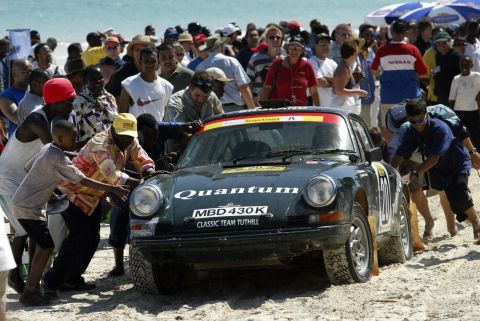 Britons Stuart Rolt and Richard Tuthill receive assistance from the public near Mombasa, southeast Kenya, during the 2003 East African Safari Classic. Fifty three cars lined up to race that year, each manufactured in 1971 or earlier. 