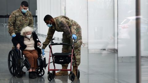 Muriel Mandell is helped out of Manhattan's Javits Center with support from military medical personnel after getting a Covid-19 vaccination.