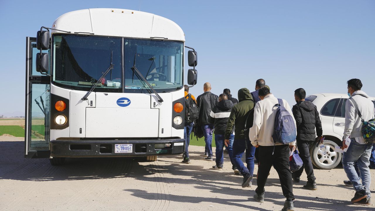 Asylum seekers board a bus to be transported to an immigration facility, after crossing the Mexico/USA border into Yuma on February 21, 2022 in Yuma, Arizona, United States. 