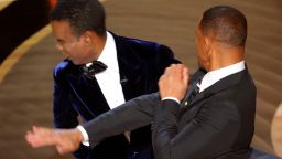 Will Smith (R) hits Chris Rock as Rock spoke on stage during the 94th Academy Awards in Hollywood, Los Angeles, California, U.S., March 27, 2022. 