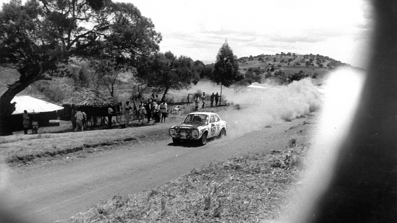 A car drives through a rural area during the 1971 rally. The nature of the event is heavily determined by local conditions, which range from incredibly dusty to heavy mud, putting vehicles and their drives through their paces.