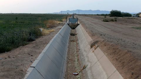 A dry irrigation canal that runs through land farmed by Tempe Farming Company, in Casa Grande, Arizona. The Colorado River has been a go-to source of water for cities, tribes and farmers in the West for decades. A water shortage was declared for the first time on the river last year.