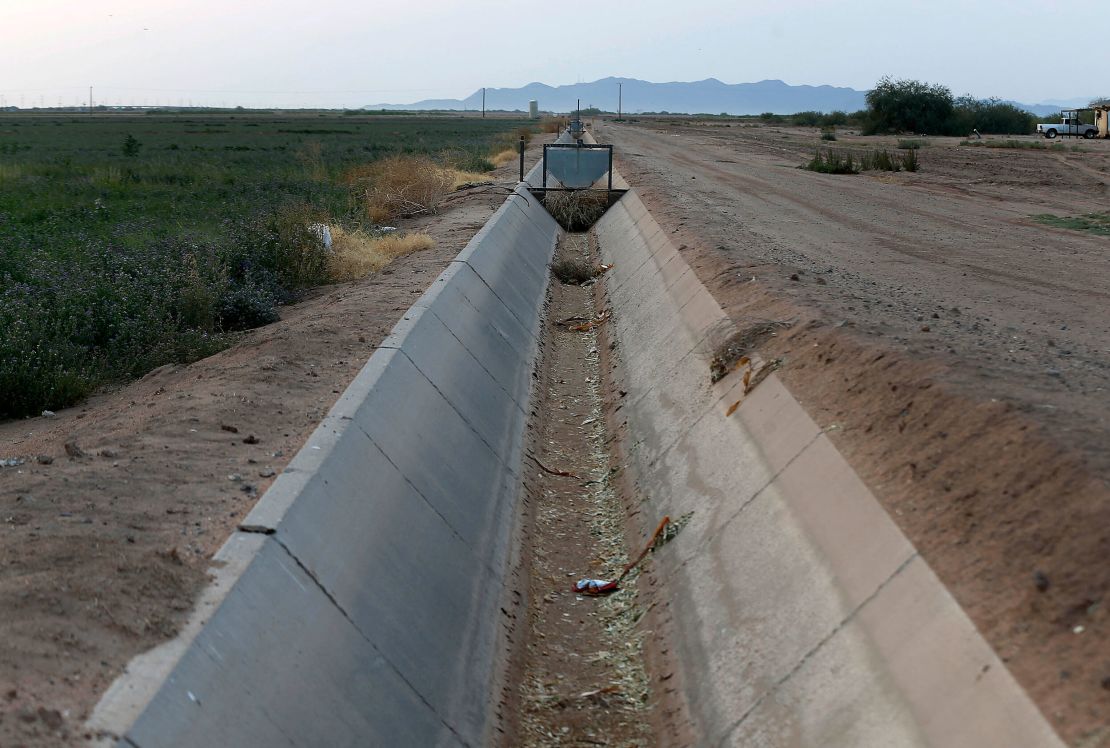 A dry irrigation canal that runs through land farmed by Tempe Farming Company, in Casa Grande, Arizona. The Colorado River has been a go-to source of water for cities, tribes and farmers in the West for decades. A water shortage was declared for the first time on the river last year.