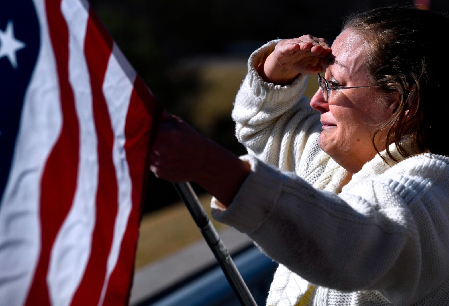 Angela Maltby holds an American flag and salutes while attending the funeral procession for Eastland Sheriff's Deputy Barbara Fenley, <a href="index.php?page=&url=https%3A%2F%2Fwww.cnn.com%2F2022%2F03%2F18%2Fus%2Feastland-complex-fire-texas-evacuation-order%2Findex.html" target="_blank">who died while helping people escape a wildfire.</a>