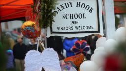 A pair of angel wings and balloons stand after being offered at a makeshift shrine to the victims of a elementary school shooting in Newtown, Connecticut, December 16, 2012.  A young gunman slaughtered 20 small children and six teachers on December 14,2012 after walking into a school in an idyllic Connecticut town wielding at least two sophisticated firearms. AFP PHOTO/Emmanuel DUNAND (Photo by Emmanuel DUNAND / AFP) (Photo by EMMANUEL DUNAND/AFP via Getty Images)
