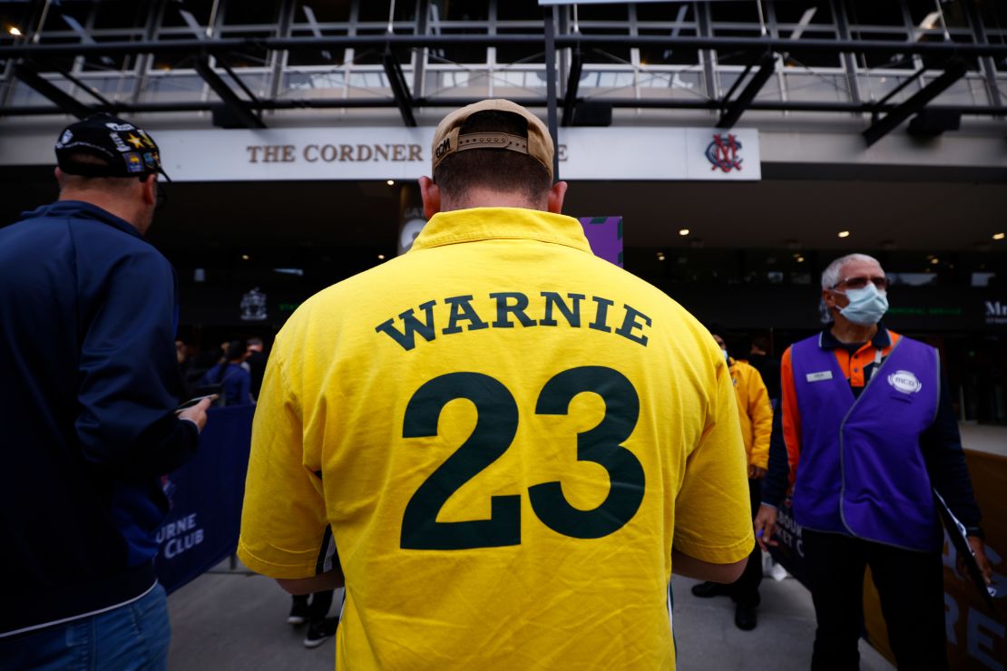 A man wearing a "Warnie" jersey attends the state memorial service for former Australian cricketer Warne.