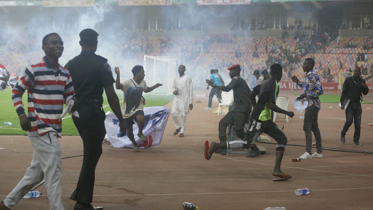 Police use tear gas to disperse pitch invaders during the World Cup qualifier between Nigeria and Ghana.