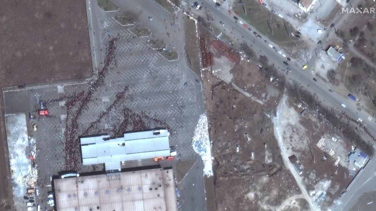Hundreds of people gather in lines outside the Metro supermarket in western Mariupol.