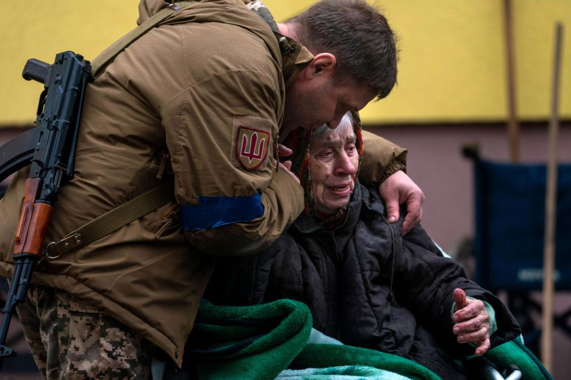 A soldier comforts Larysa Kolesnyk, 82, after being evacuated from Irpin, on the outskirts of Kyiv, on March 30, 2022.