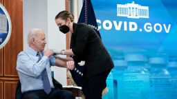 President Joe Biden rolls up his sleeve before receiving his second COVID-19 booster shot in the South Court Auditorium on the White House campus, Wednesday, March 30, 2022, in Washington. 