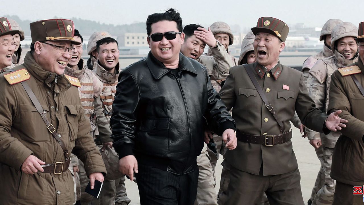 North Korean leader Kim Jong Un (C) walks with North Korean military personnel during the test launch operation of what state media reports is a new type of intercontinental ballistic missile, in an undisclosed location in North Korea, March 24, 2022.