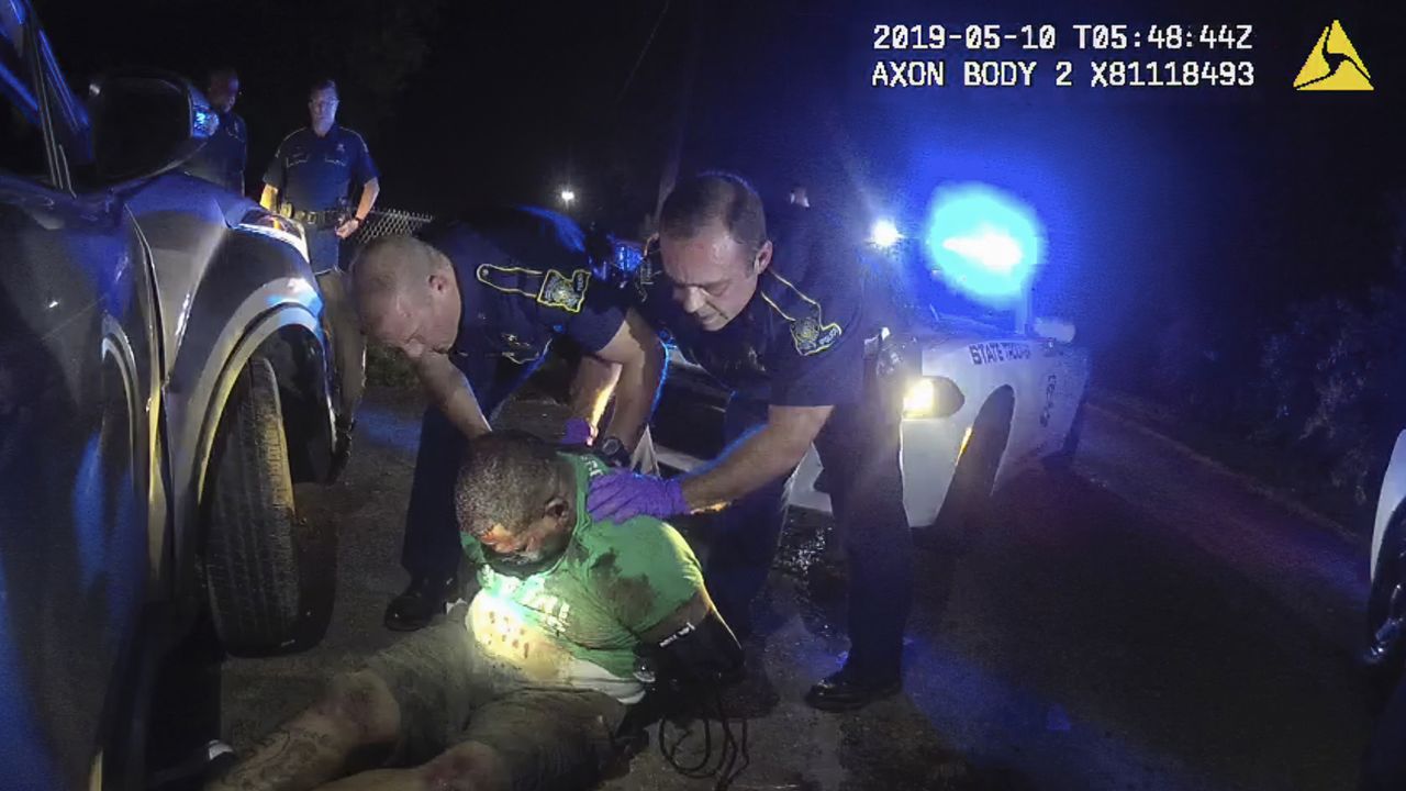 This image from the body camera of Louisiana State Police Trooper Dakota DeMoss shows his colleagues, Kory York, center left, and Chris Hollingsworth, center right, holding up Ronald Greene before paramedics arrived on May 10, 2019, outside of Monroe, Louisiana. 