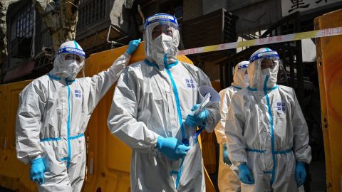 Covid workers in hazmat suits outside a sealed-off neighborhood during Shanghai's months-long lockdown this year.