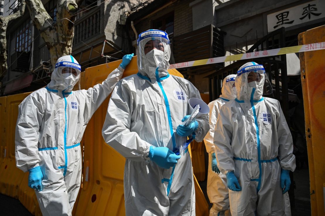 Covid workers in hazmat suits outside a sealed-off neighborhood during Shanghai's months-long lockdown this year.
